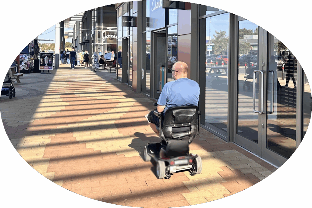 man on mobility scooter in front of shops
